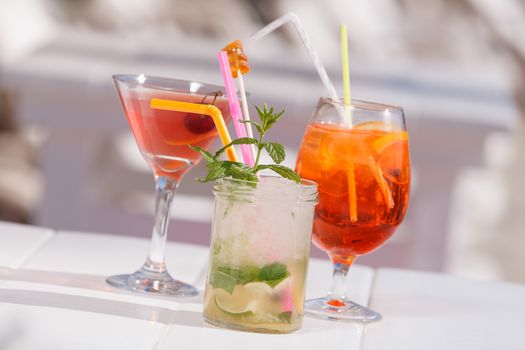 Three refreshing summer cocktails at a beach bar. Selective focus