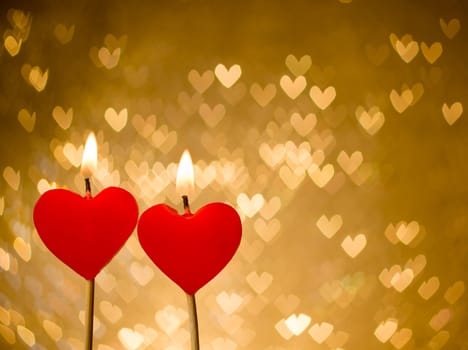 red hearts candles on golden hearts bokeh as background, valentine day and love concept