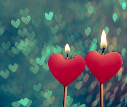 red hearts candles on vintage hearts bokeh as background, valentine day and love concept