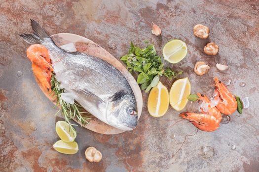 Sea bream, shrimp and fresh raw ingredients ready for cooking, top view