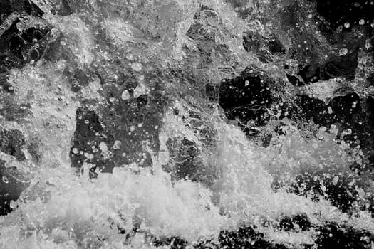 a wave splashes over the sea on a Sunny day