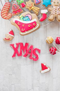 Various types of Christmas decorative cookies decorated with sugar icing on cooling rack
