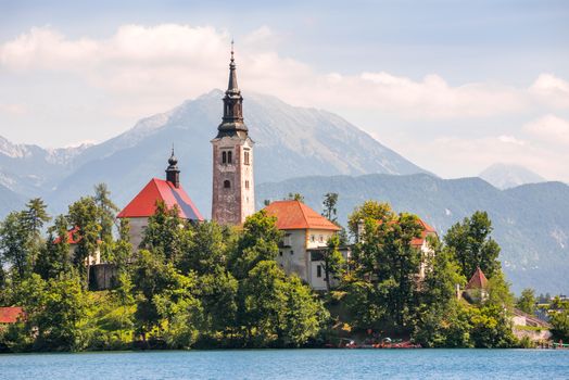 Little Island with Catholic Church on Bled Lake, Slovenia with Mountains in Background