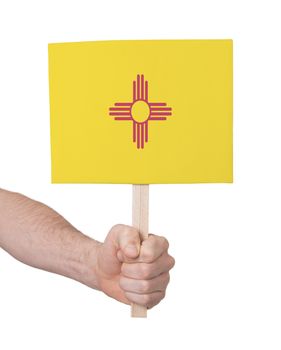 Hand holding small card, isolated on white - Flag of New Mexico