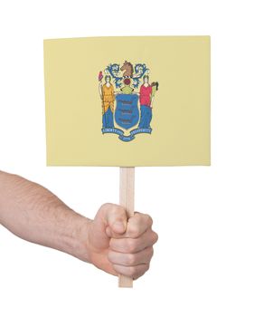 Hand holding small card, isolated on white - Flag of New Jersey