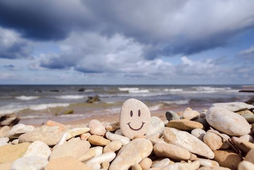 Emoticon by pebbles on the seashore