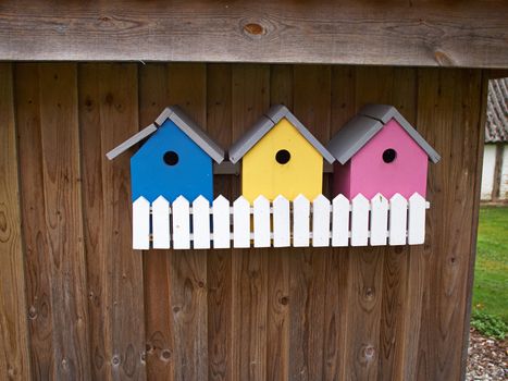 Colorful creative wooden nesting boxes birdhouse hanged on a wall in backyard