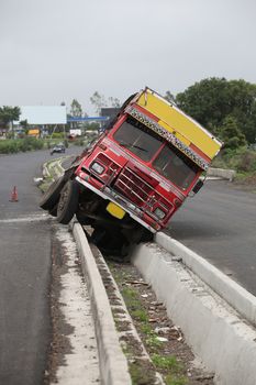 An accident of a truck stuck in the rainwater drain passage on an Indian highway
