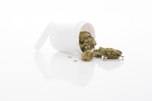 Medical marijuana. Cannabis bud and white container isolated on white background with reflection