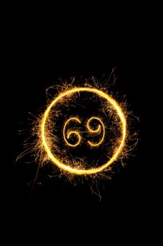 Number 69 in sparkling digits isolated on black background. Symbol of sexual position 69.