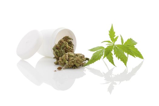 Medical marijuana. Cannabis bud and hemp leaf and white container isolated on white background with reflection
