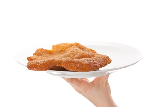 Female hand holding a plate with wiener schnitzel isolated on white background with reflection. Traditional european cuisine.