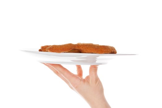 Female hand holding a plate with wiener schnitzel isolated on white background with reflection. Traditional european cuisine.