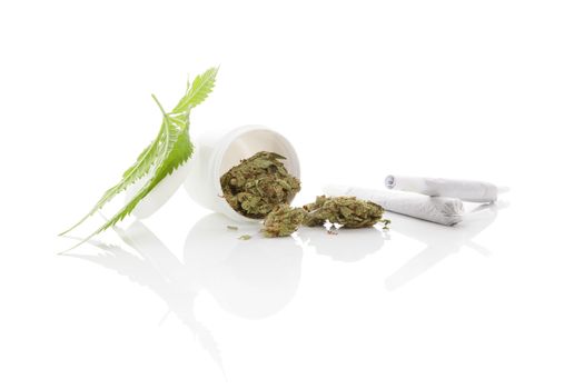 Medical marijuana. Cannabis bud and leaf and white container isolated on white background with reflection