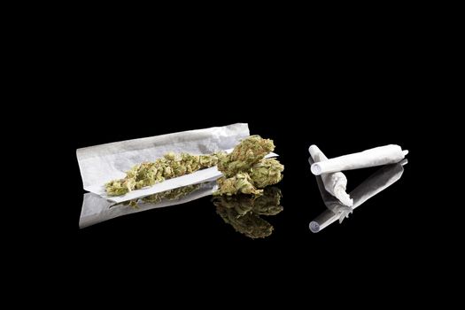 Marijuana background. Cannabis cigarette joint, bud and hemp leaves isolated on black background. Addictive drug or alternative medicine. 