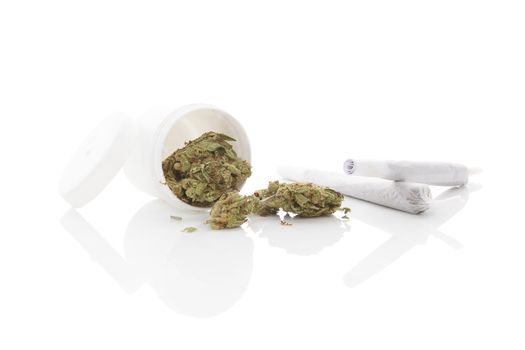 Medical marijuana. Cannabis bud and white container isolated on white background with reflection
