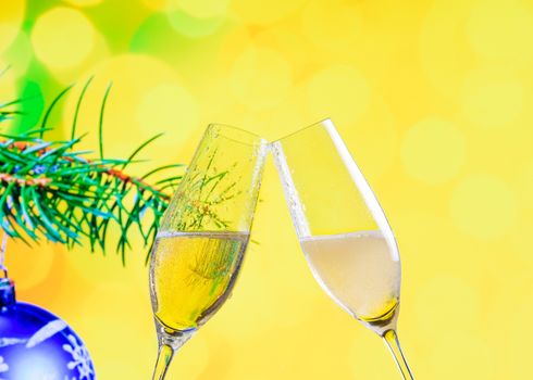 champagne flutes with golden bubbles make cheers on christmas decoration yellow bokeh background, christmas atmosphere