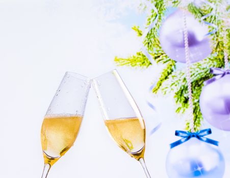 champagne flutes with golden bubbles make cheers on christmas tree decoration background, christmas atmosphere