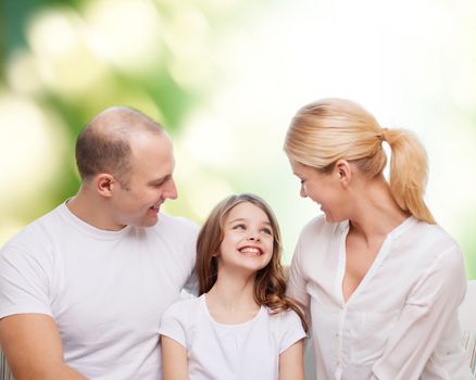 family, childhood, ecology and people - smiling mother, father and little girl over green background