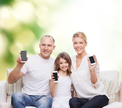 summer, technology, advertisement and people concept - smiling family with smartphones over green background