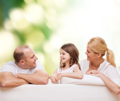 family, childhood, ecology and people - smiling mother, father and little girl over green background