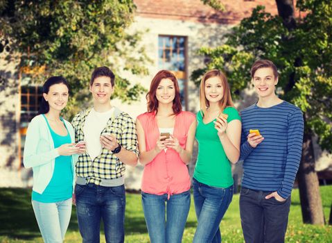 education and modern technology concept - smiling students with smartphones