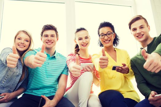 education, school and technology concept - smiling students with smartphone texting at school