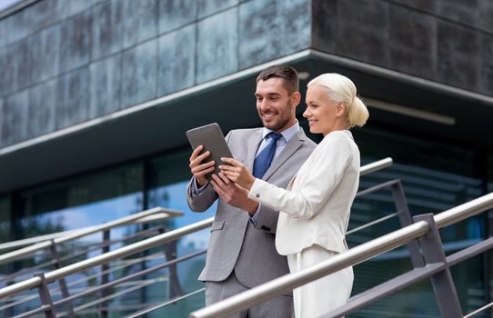 business, partnership, technology and people concept - smiling businessman and businesswoman working with tablet pc computer on city street