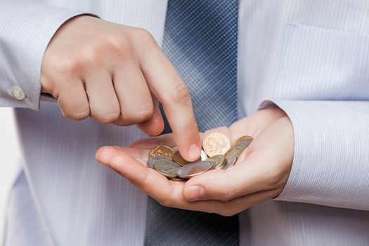 Business risks and finance issues concept - businessman hand holding coin savings counting money profit or losses