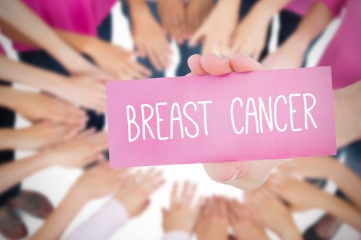 The word breast cancer and young woman holding blank card against oktoberfest graphics
