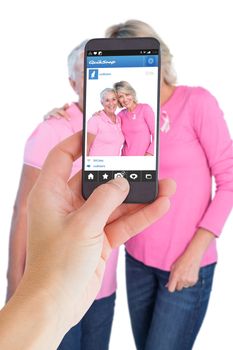 Female hand holding a smartphone against photo sharing app
