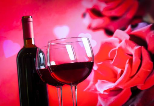 two red wine glasses on blur red roses background, festive and love concept