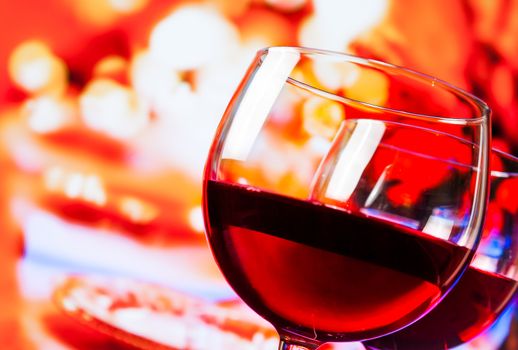 detail of red wine glasses against unfocused restaurant table background, festive and fun concept