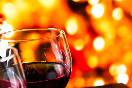 red wine glasses against colorful unfocused lights background, festive and fun concept