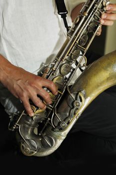 Hands of the saxophonist with a saxophone 