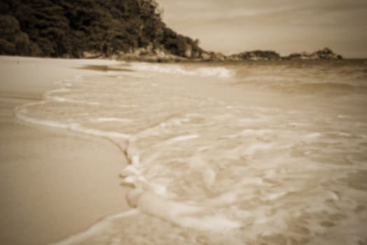 Vintage style blurred photograph in sepia colour for background, beautiful landscape sea and waves on beach in summer at Koh Miang island, Mu Ko Similan National Park, Phang Nga province, Thailand