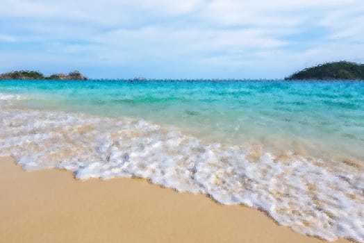Blurred photograph by glass filter for background beautiful landscape blue sea and white waves on beach in summer at Koh Miang island, Mu Ko Similan National Park, Phang Nga province, Thailand