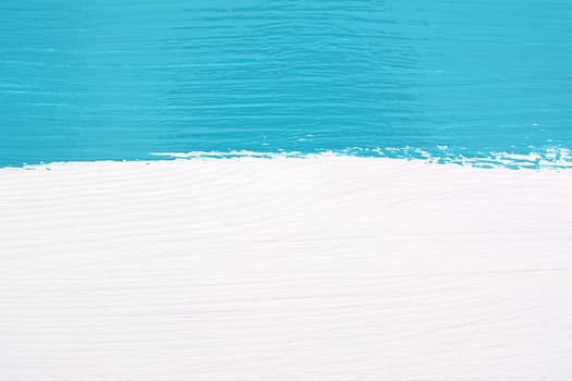 Horizontal stripe of teal paint over white painted wooden background