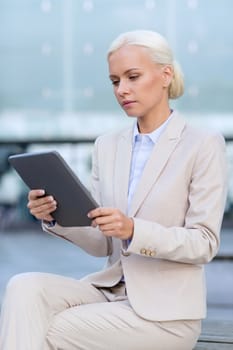 business, education, technology and people concept - businesswoman working with tablet pc computer on city street