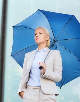 business, bad weather and people and concept - young serious businesswoman with umbrella outdoors