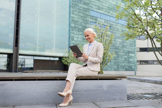 business, education, technology and people concept - smiling businesswoman working with tablet pc computer on city street