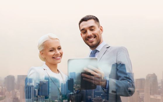 business, partnership, technology and people concept - smiling businessman and businesswoman with tablet pc computer over city background