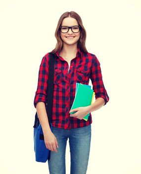 education and people concept - smiling female student in eyeglasses with laptop bag and notebooks