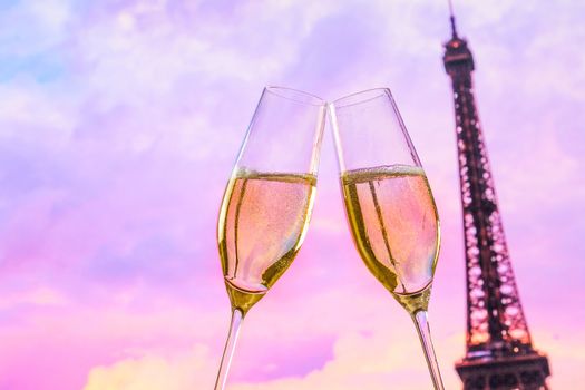 a pair of champagne flutes with golden bubbles make cheers on blur tower Eiffel background valentine day concept