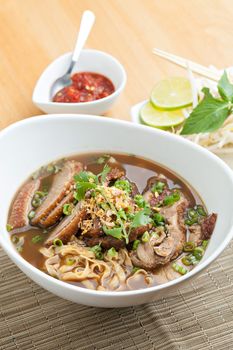 Closeup of some Thai soup with duck and rice noodles.