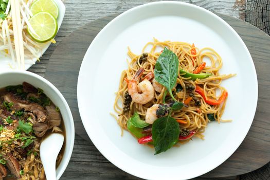 Thai food dishes with shrimp and noodles and soup with duck.