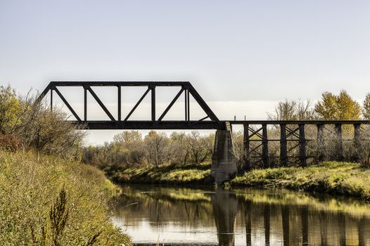 A rail bridge that crosses the narrow Battle River of Saskatchewan