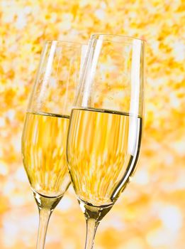 two champagne flutes on golden light background, luxury concept