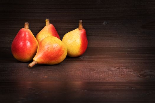 In the picture four pears "Angelica" Typical Italian, placed on wooden boards brown and empty space on the right.