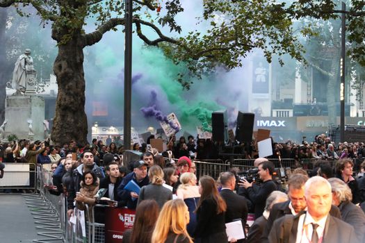UNITED KINGDOM, London: Feminist protesters hold posters and release green and purple smoke bombs to highlight cuts to domestic violence services during the screening of Suffragette on opening night of the BFI London Film Festival at London's Odeon Leicester Square on October 7, 2015.
